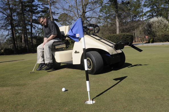 man-putting-while-sitting-on-golf-cart